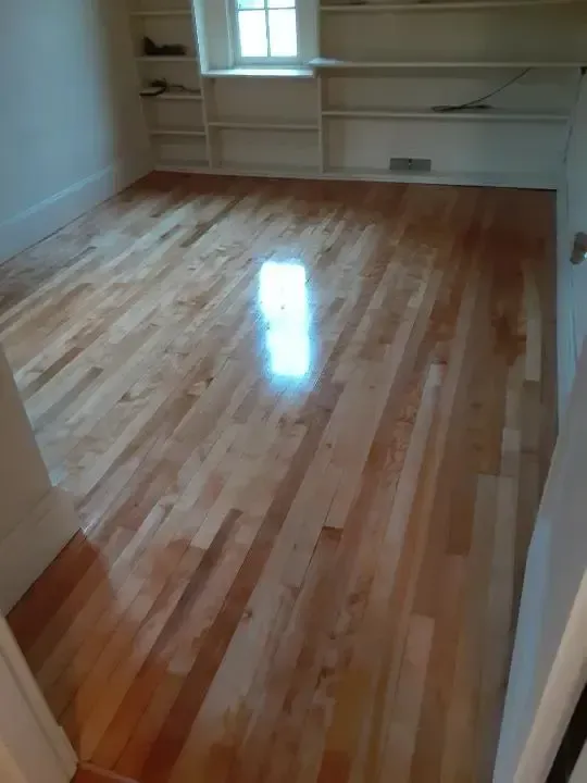 A room with hardwood floors and shelves in it