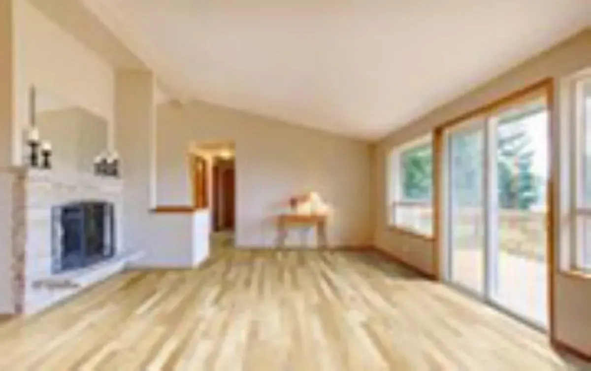 A living room with hardwood floors , a fireplace and sliding glass doors.