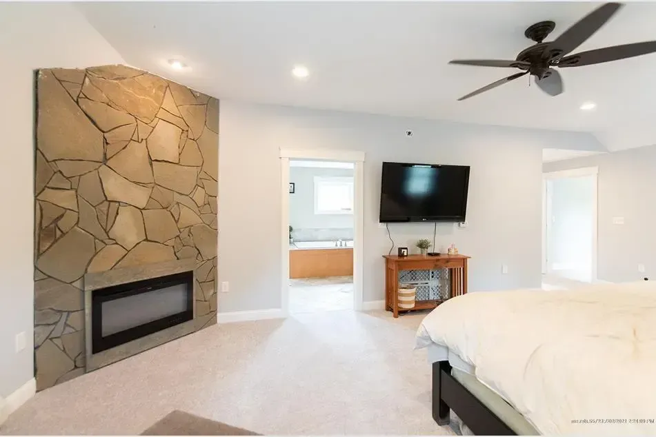 A bedroom with a fireplace and a flat screen tv