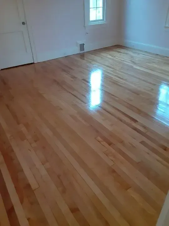 A room with a wooden floor and a window.