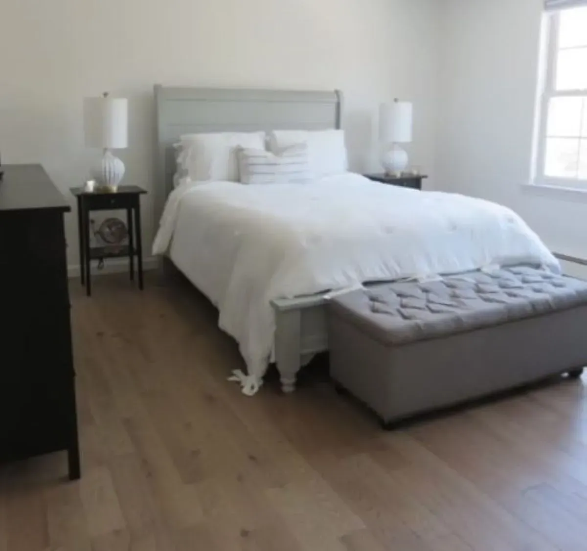 A bedroom with a large bed and a bench