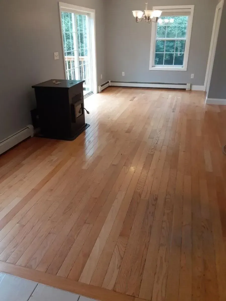 A living room with hardwood floors and a wood stove