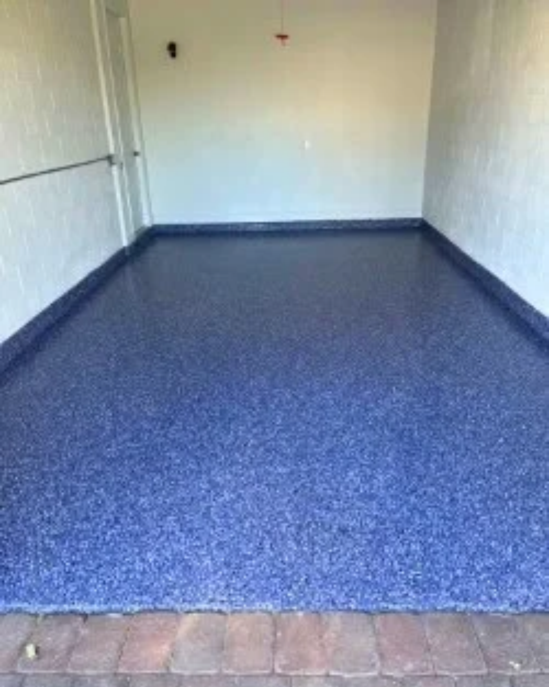 Blue flake epoxy floor installation in a garage done by Quality Floor Finishers.