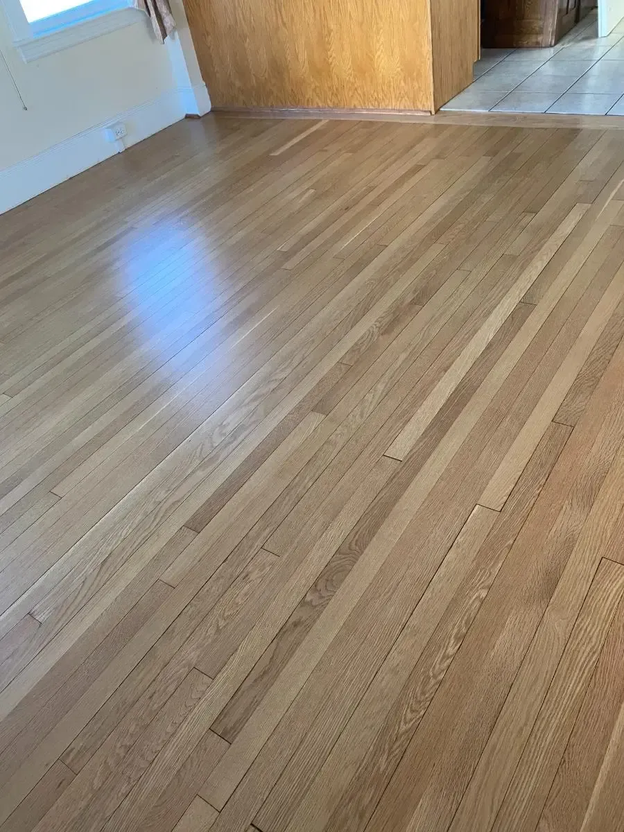 Wooden hardwood floor, light brown color, in a well-lit room.