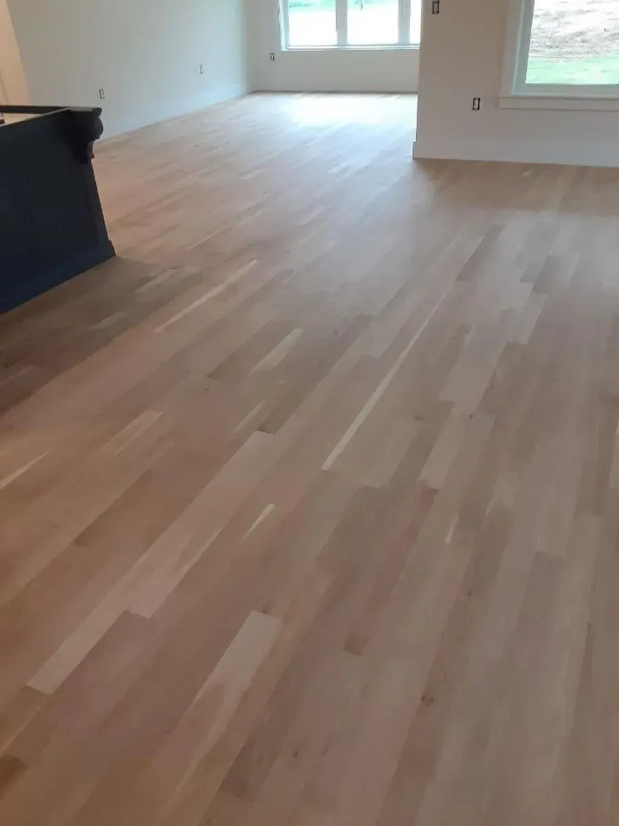 A living room with a wooden floor and white walls.