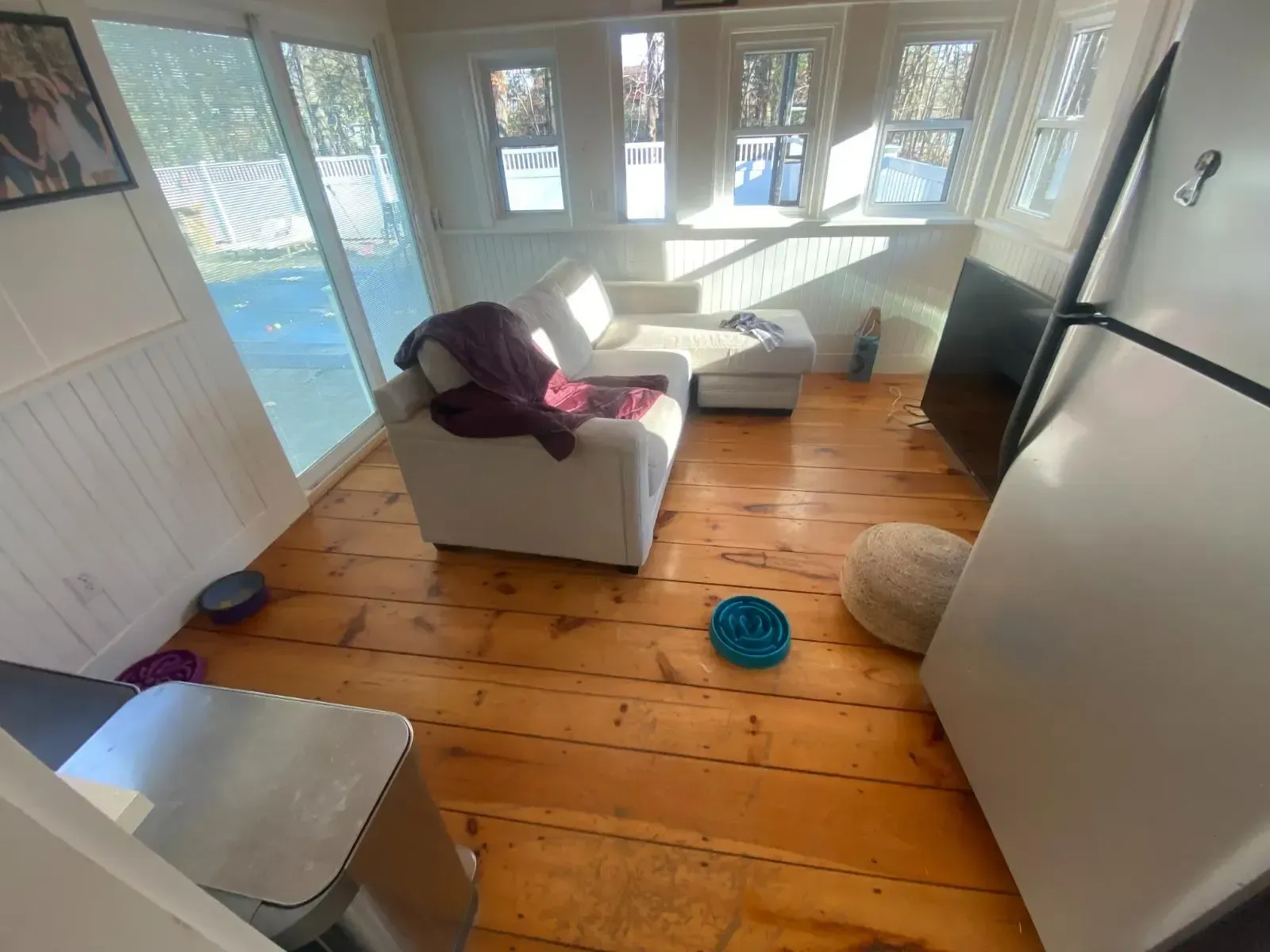 A living room with a couch and a refrigerator