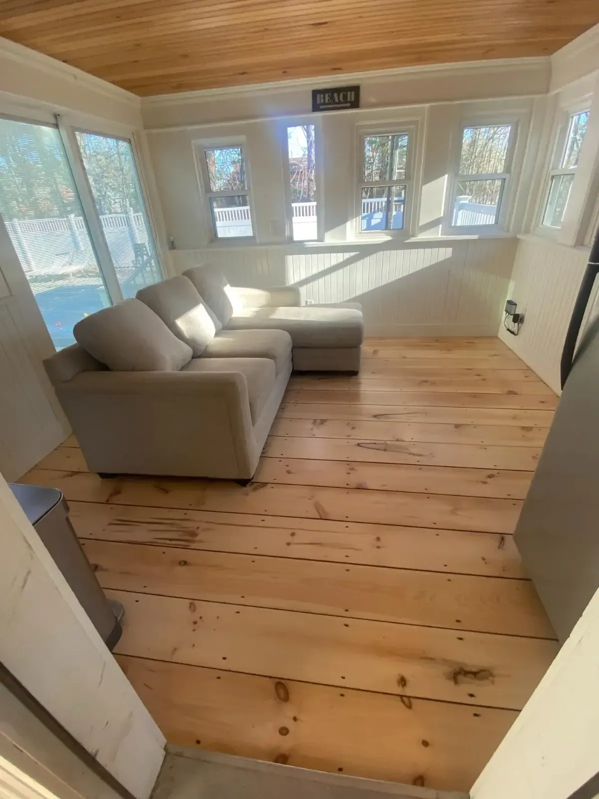 A living room with a couch and a wooden floor.