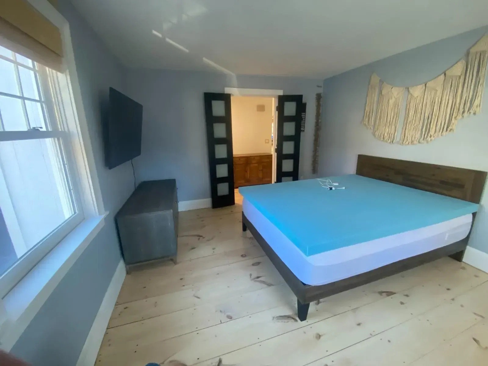 A bedroom with a large bed and a flat screen tv