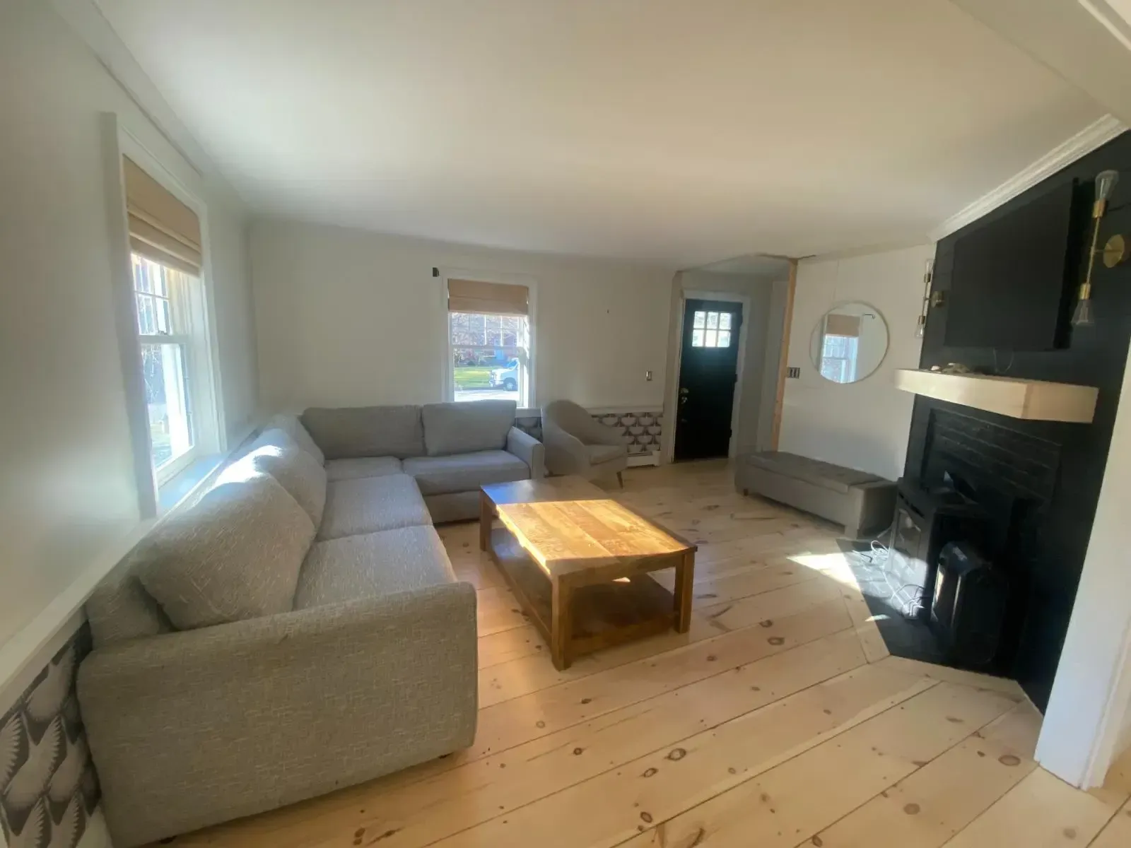 A living room with a couch , chair , coffee table and fireplace.