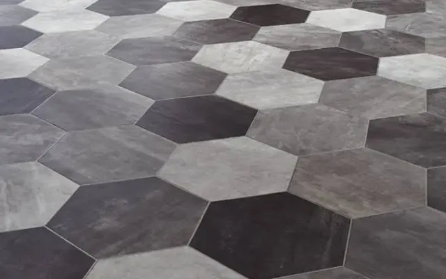 Gray and black hexagonal stone tiles arranged in a geometric floor pattern