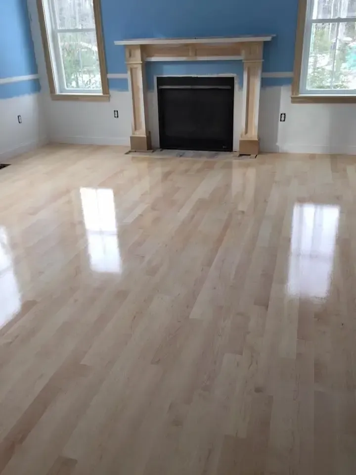 A living room with hardwood floors and a fireplace.