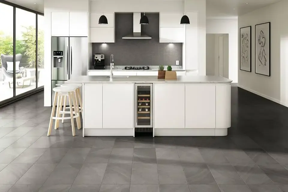 A kitchen with white cabinets and a stainless steel refrigerator