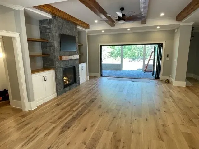 A living room with hardwood floors and a fireplace.