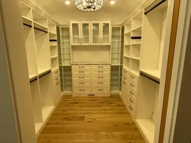 A walk in closet with lots of shelves and drawers.