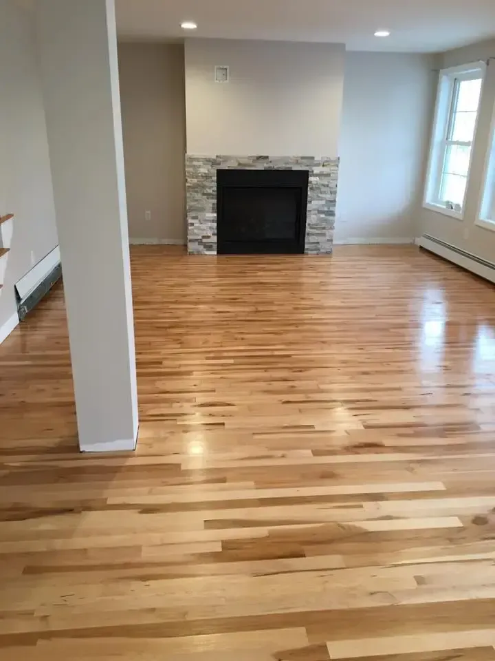 A living room with hardwood floors and a fireplace.