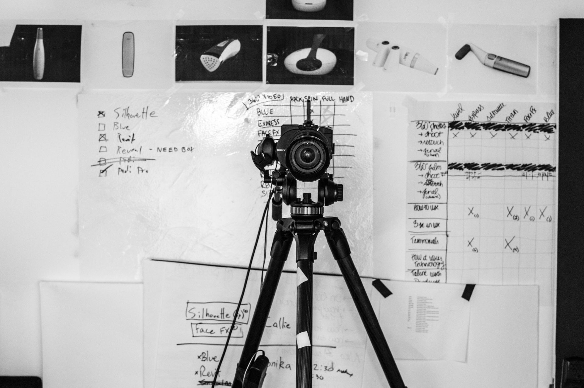 A black and white photo of a camera on a tripod