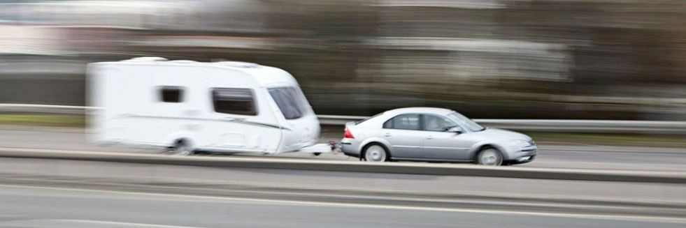 Cra towing a caravan along a motorway or dual-carriageway in UK. Blurred affect.