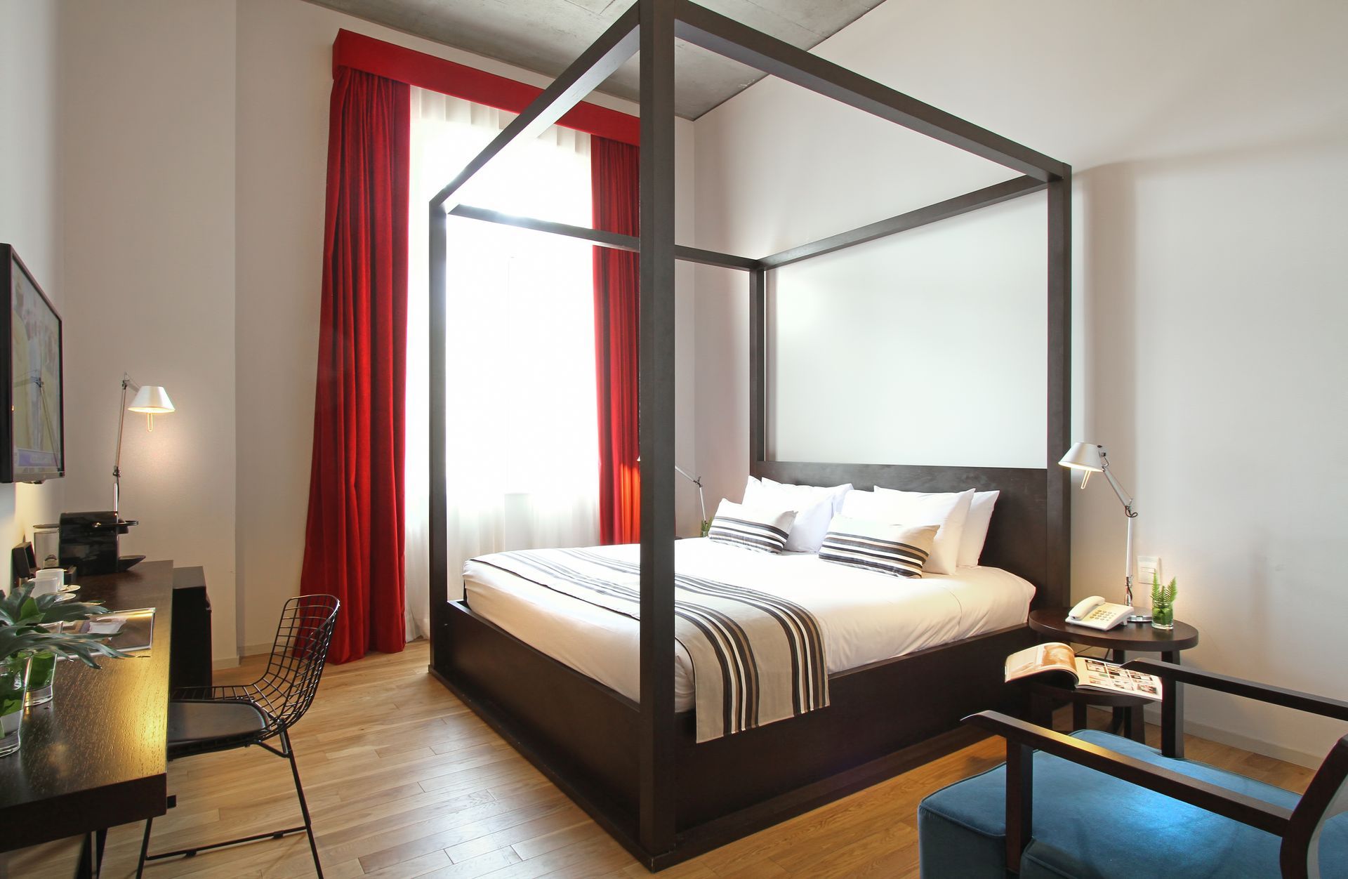 Un dormitorio con una cama con dosel y cortinas rojas