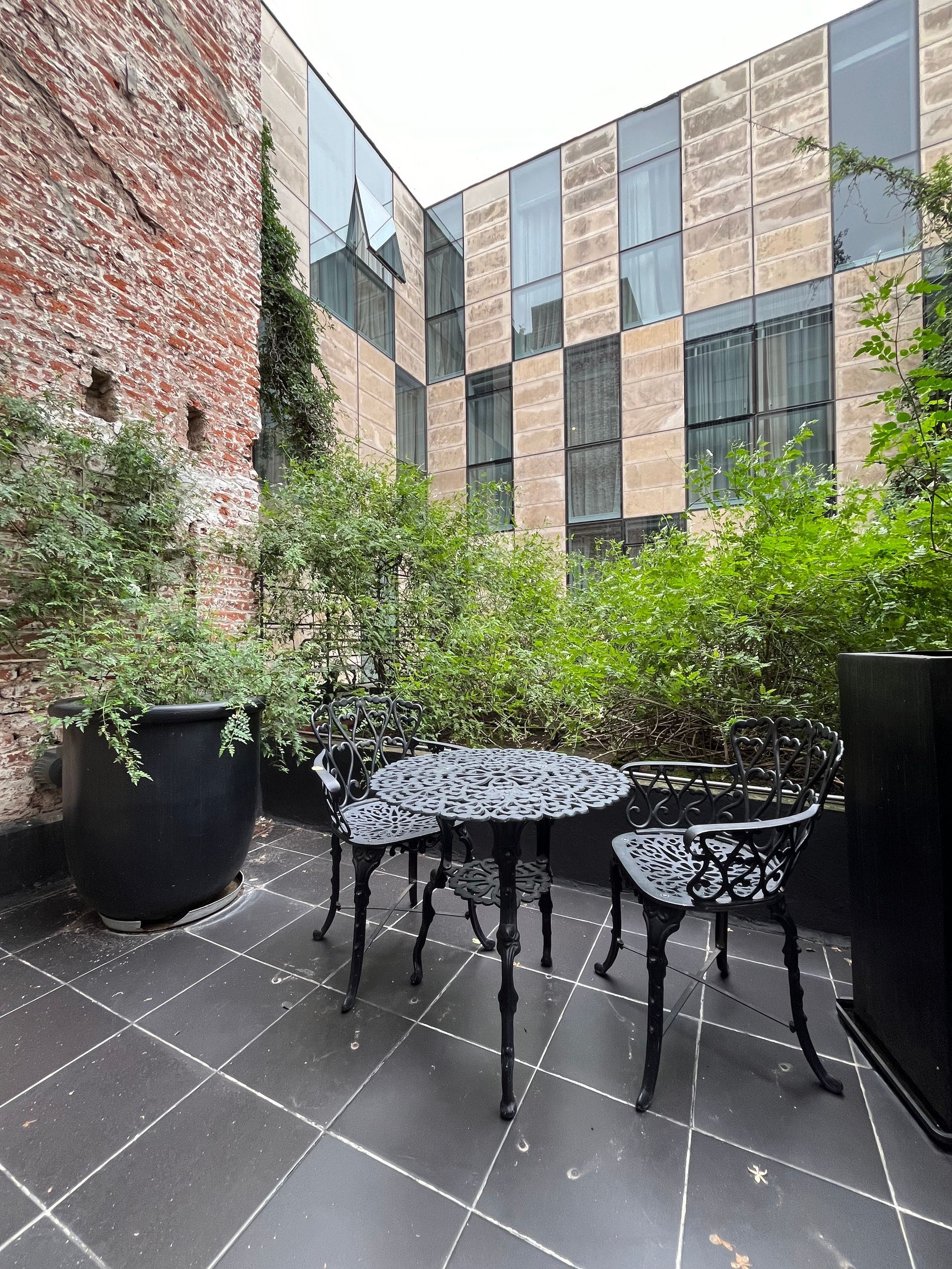 Un patio con una mesa y sillas frente a un edificio