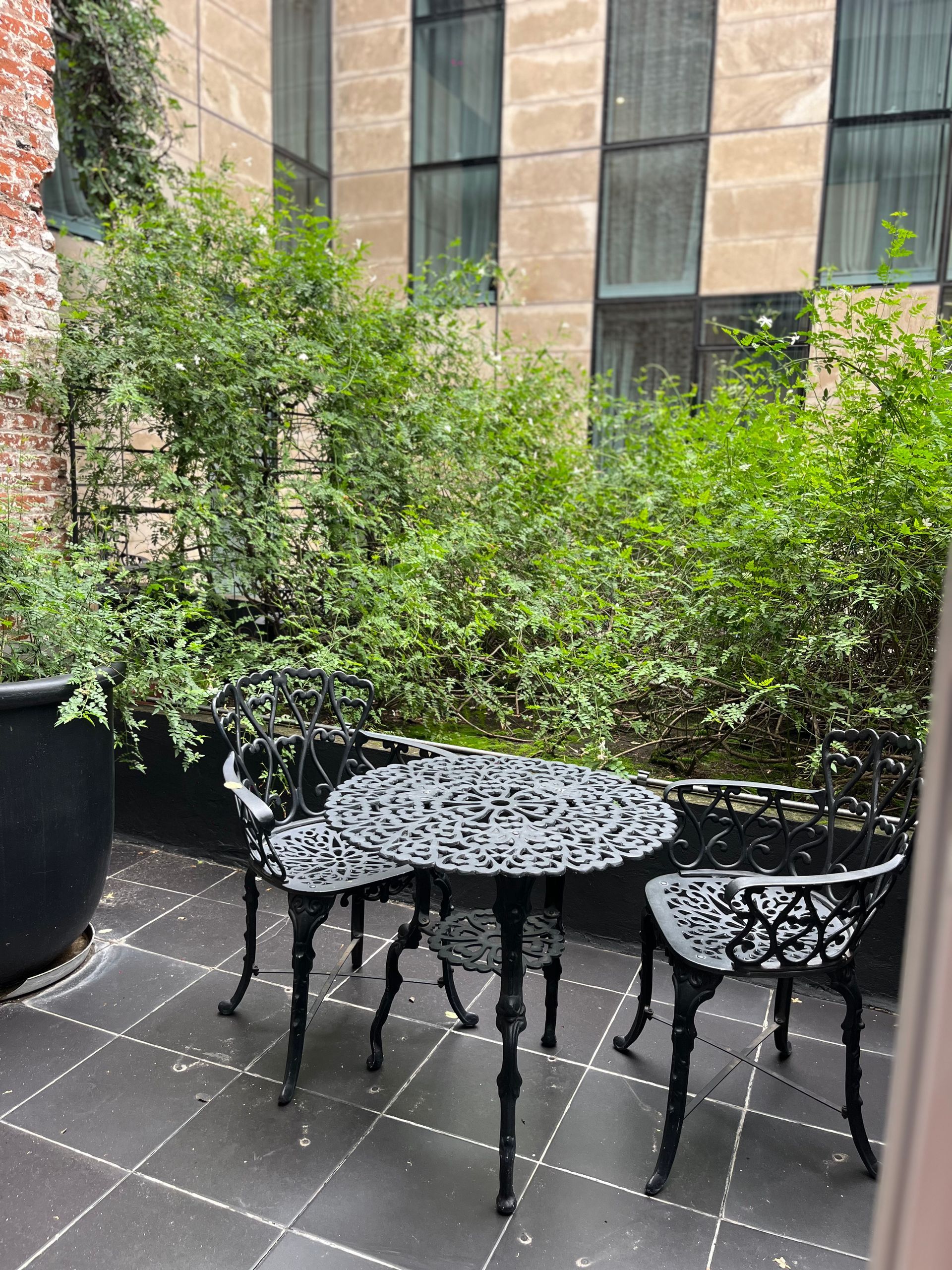 Un patio con mesa y sillas frente a un edificio.