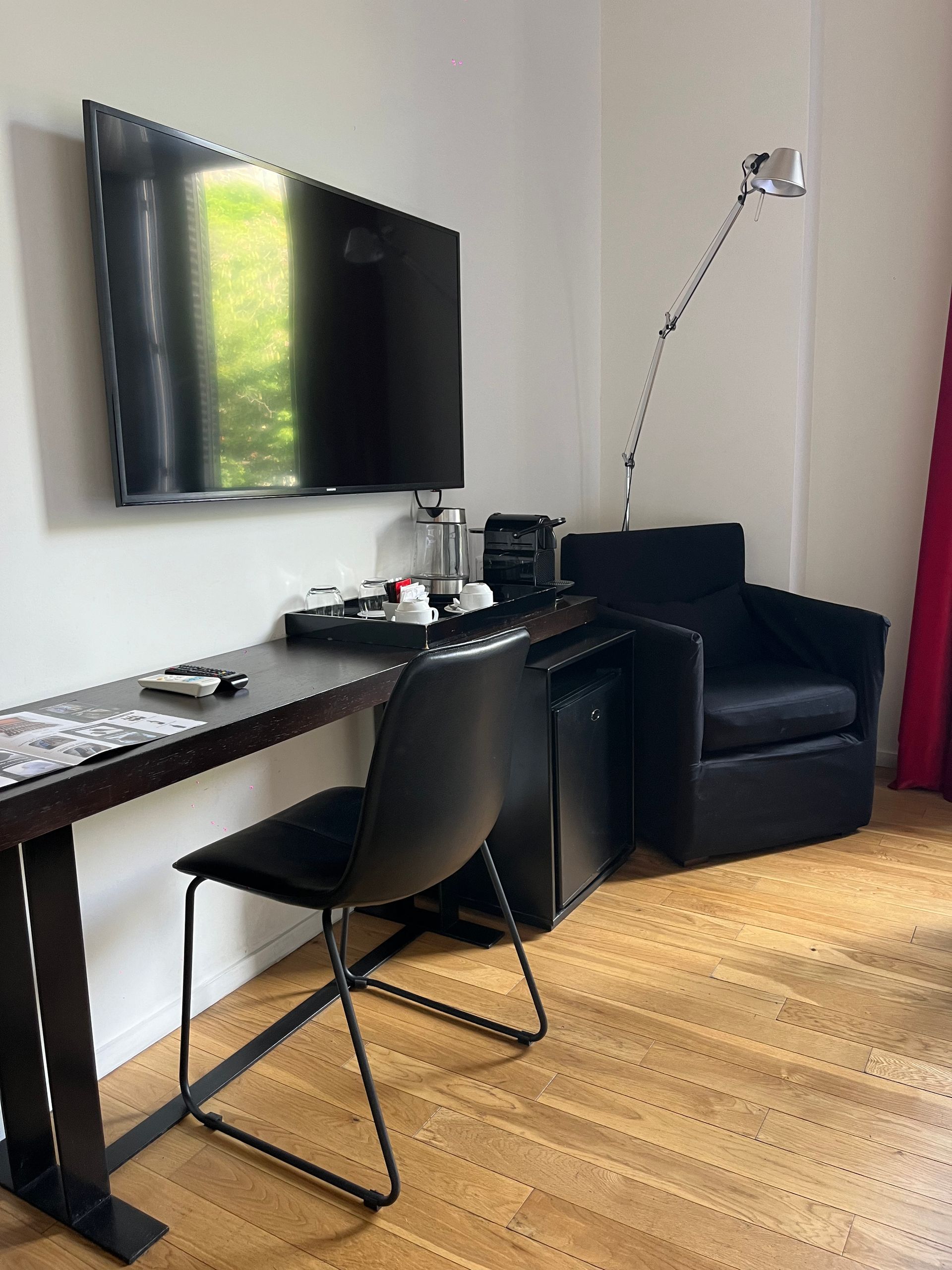 Una habitación de hotel con escritorio, silla, televisión y silla.