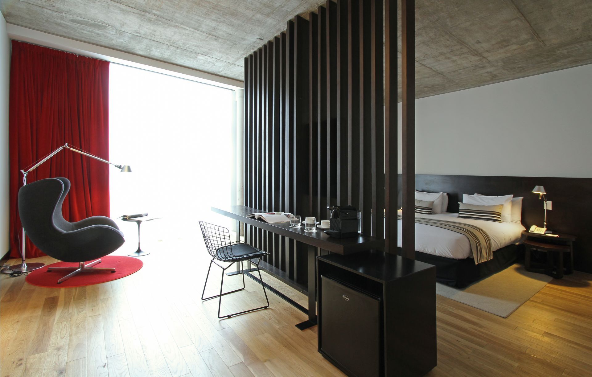 Una habitación de hotel con cama, escritorio y silla.