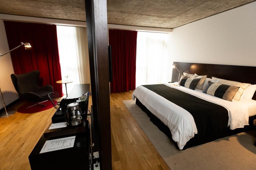 Una habitación de hotel con una cama grande y una silla