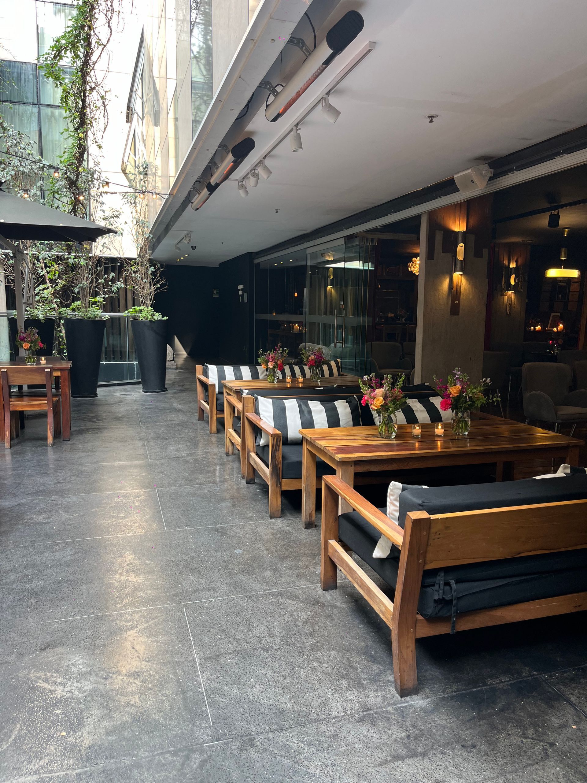 Una fila de sillas y mesas de madera fuera de un restaurante.