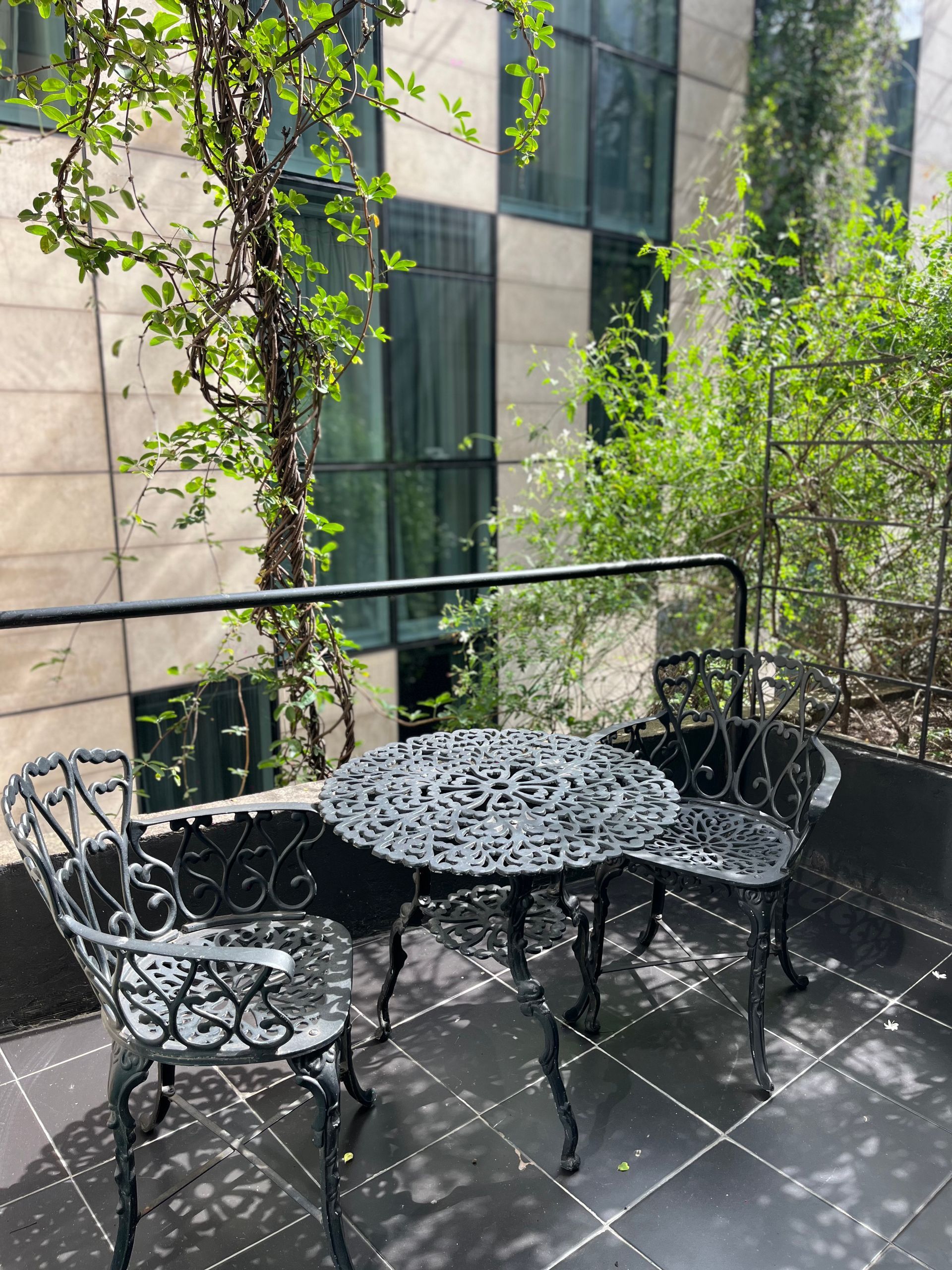 Un balcón con una mesa y sillas frente a un edificio.