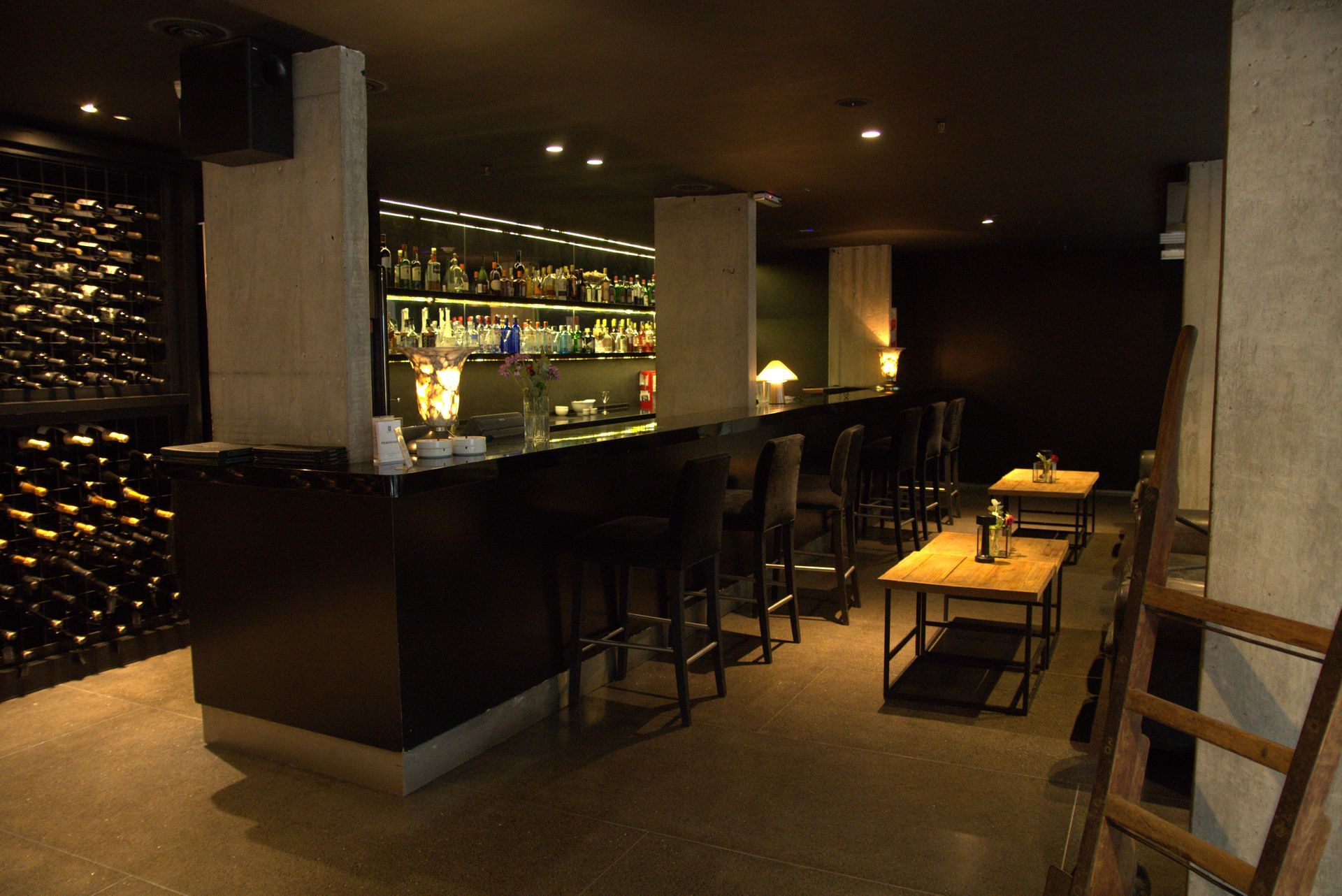 Un bar en una habitación oscura con mesas y sillas