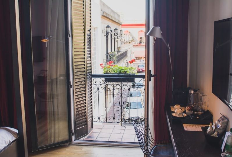 Una habitación de hotel con balcón y escritorio.