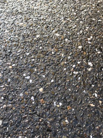 Close-up of wet gravel and small stones with gray and brown tones