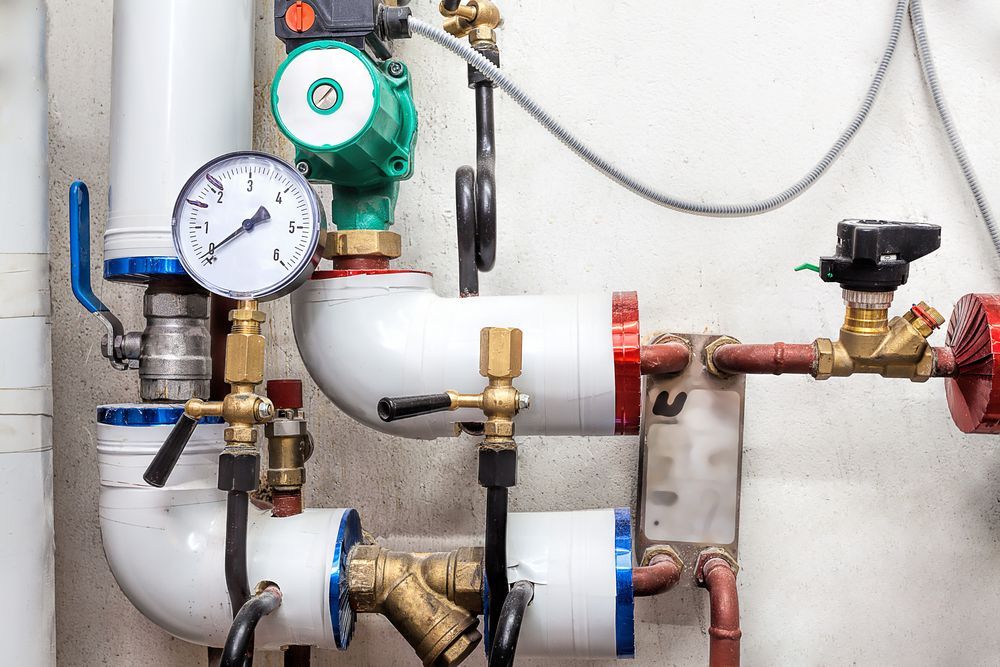 A Close Up of a Boiler Room With a Lot of Pipes and Valves — J & N Plumbing Pty Ltd In Manilla, NSW