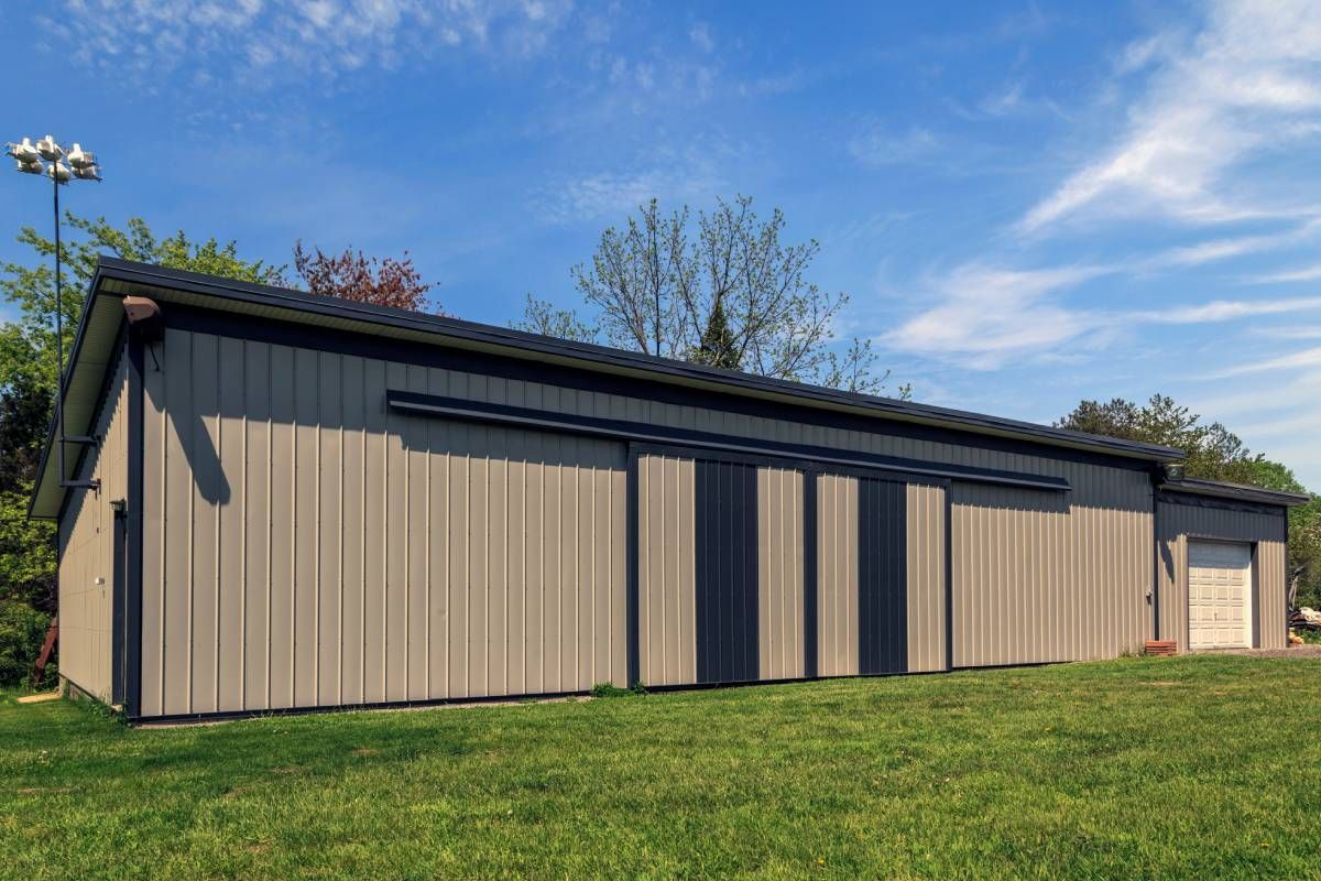 A small metal barn surrounded by grass and trees near Lexington, Kentucky (KY)