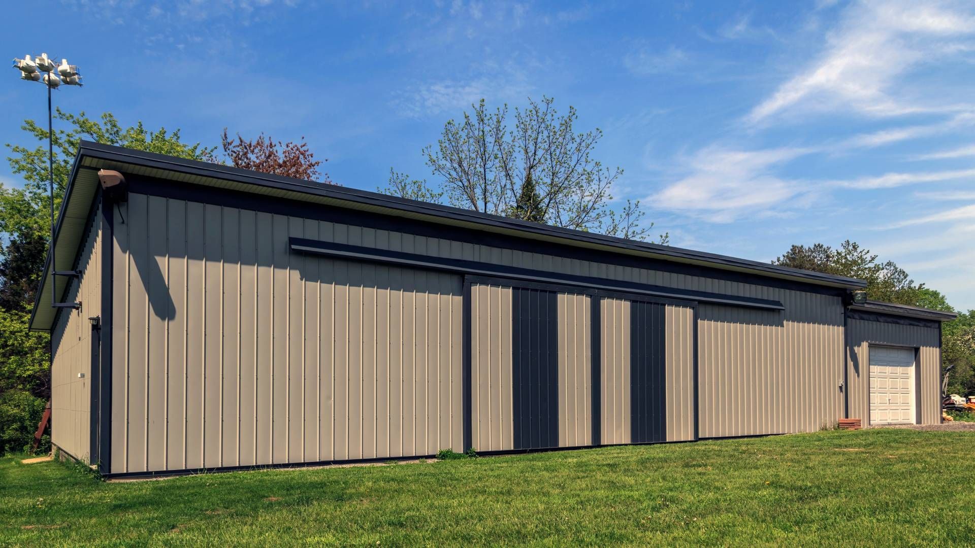 A small metal barn surrounded by grass and trees near Lexington, Kentucky (KY)