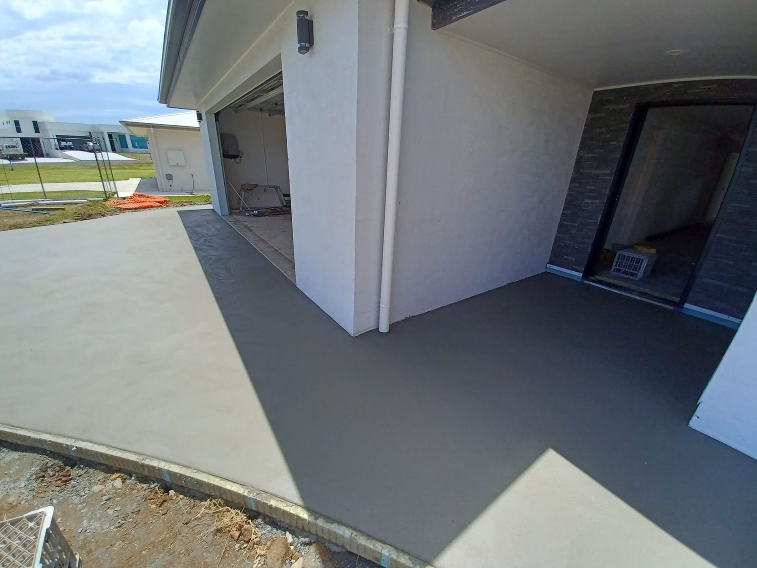 A Concrete Driveway is Being Built in Front of a House — Brocksolid Concrete in Pillar Valley, NSW