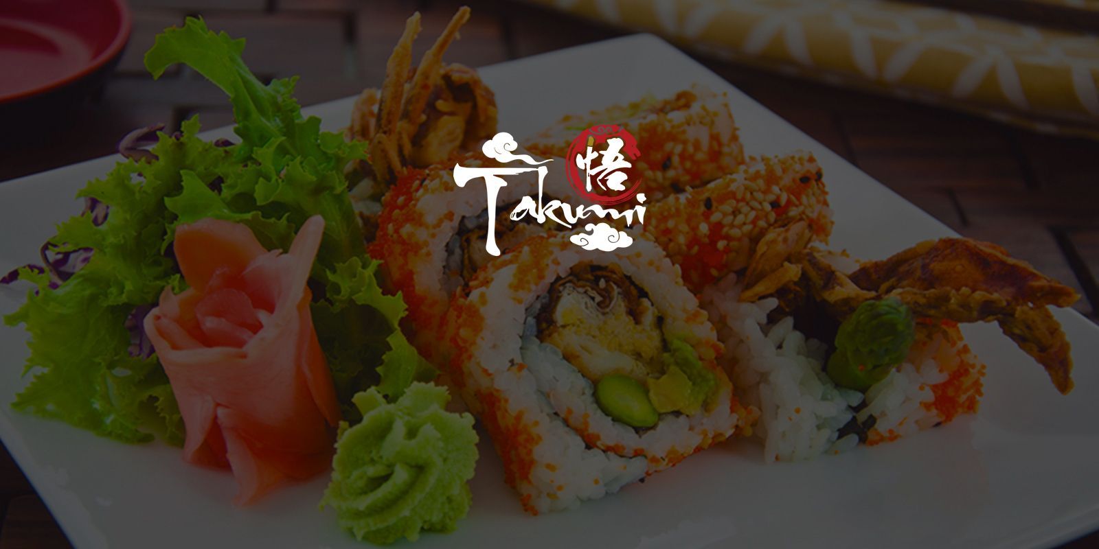 Sushi platter with tempura rolls, salmon slices, wasabi, and greens on a white plate