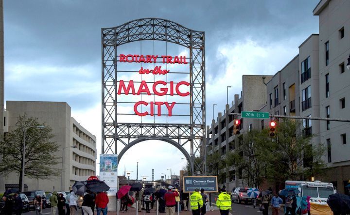 People are walking under a sign that says magic city
