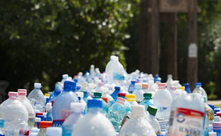 A bunch of plastic bottles are sitting on top of each other on a table.