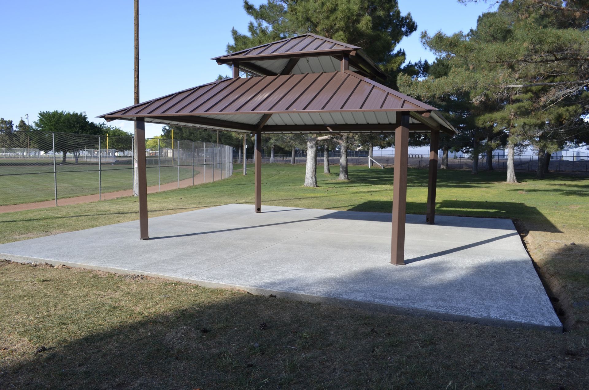 A gazebo in a park with a metal roof
