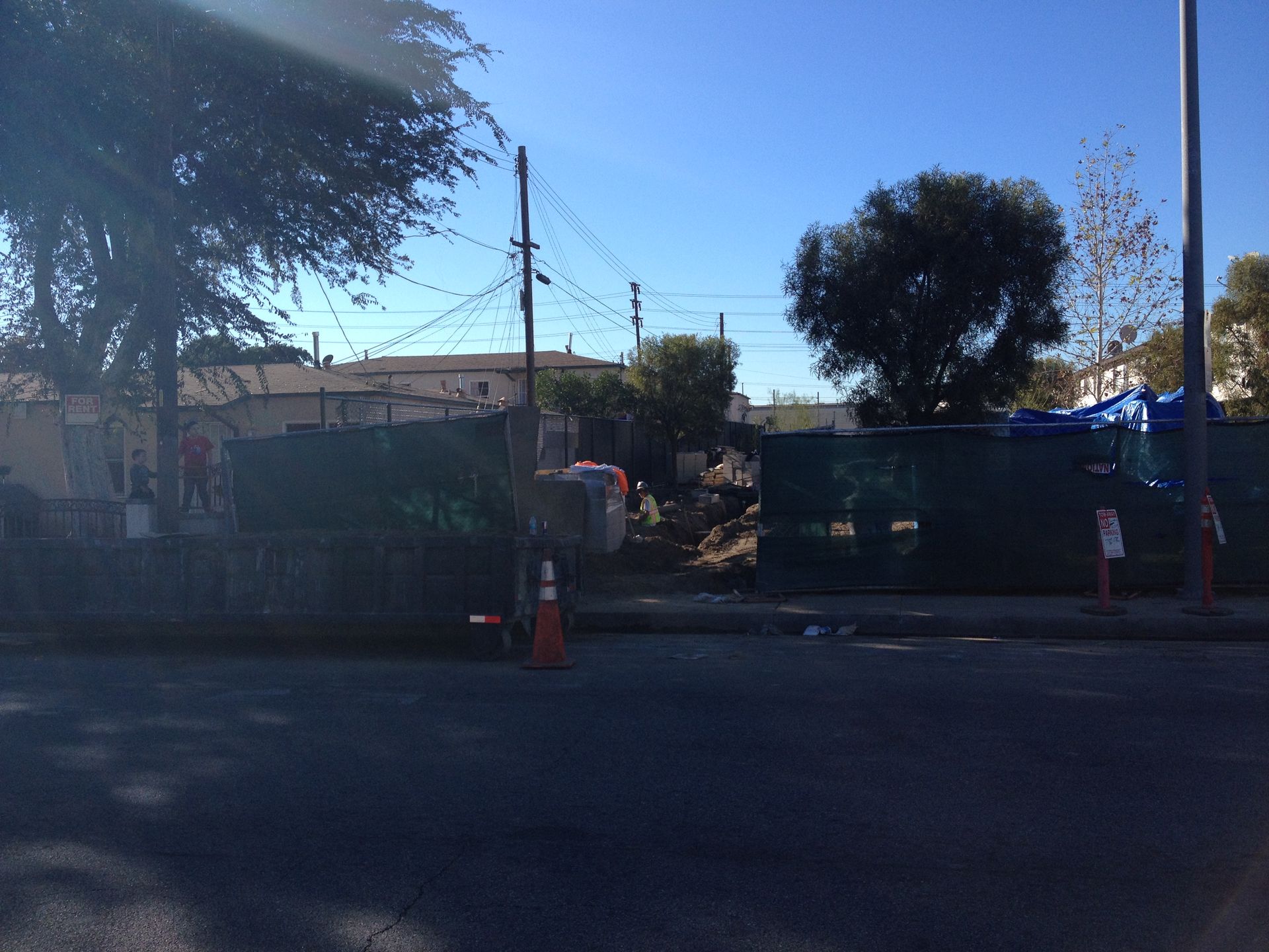 A construction site with a fence and cones on the side of the road