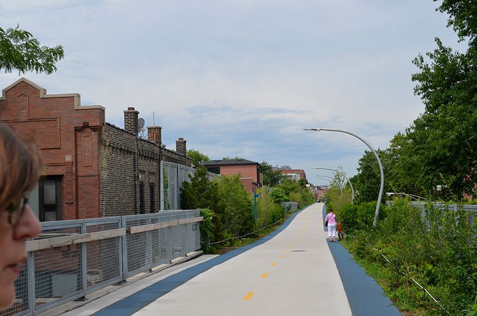 A person is walking down a path with a brick building in the background