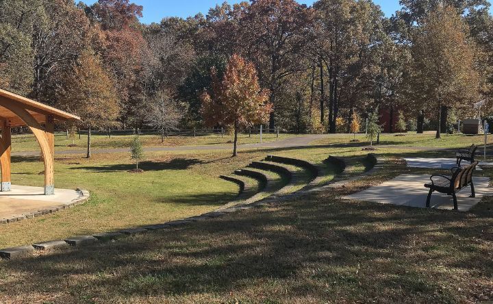 A park with a gazebo and a bench in the middle of it.