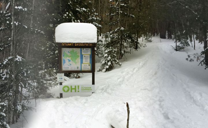 A snowy forest with a sign that says oh