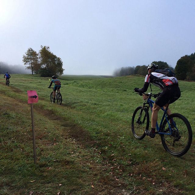 A group of people are riding bikes in a grassy field