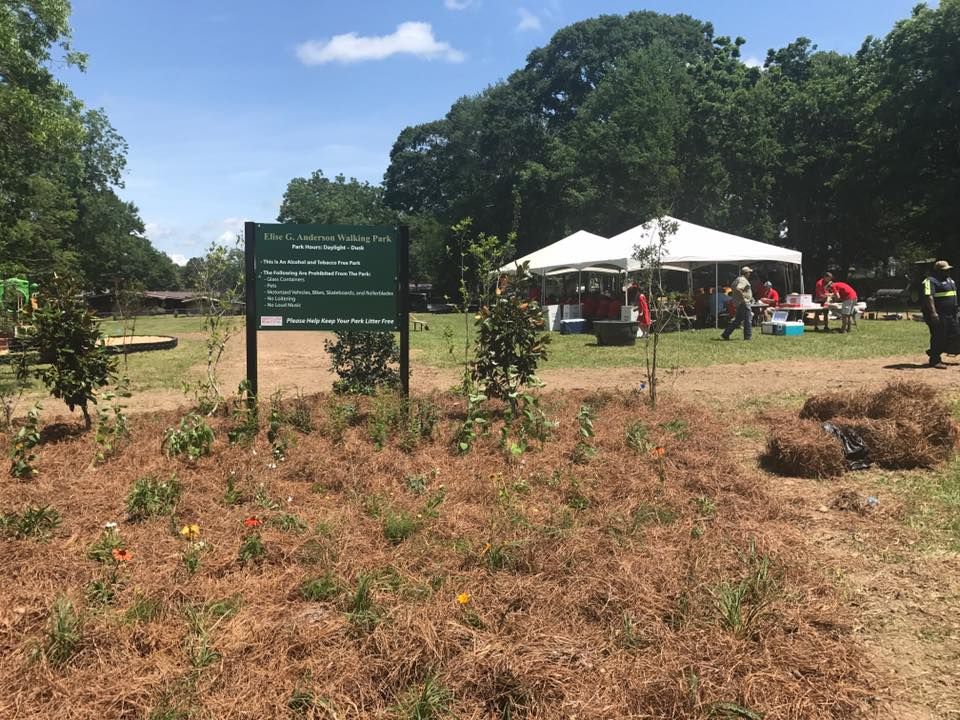 A sign in the middle of a field with trees in the background