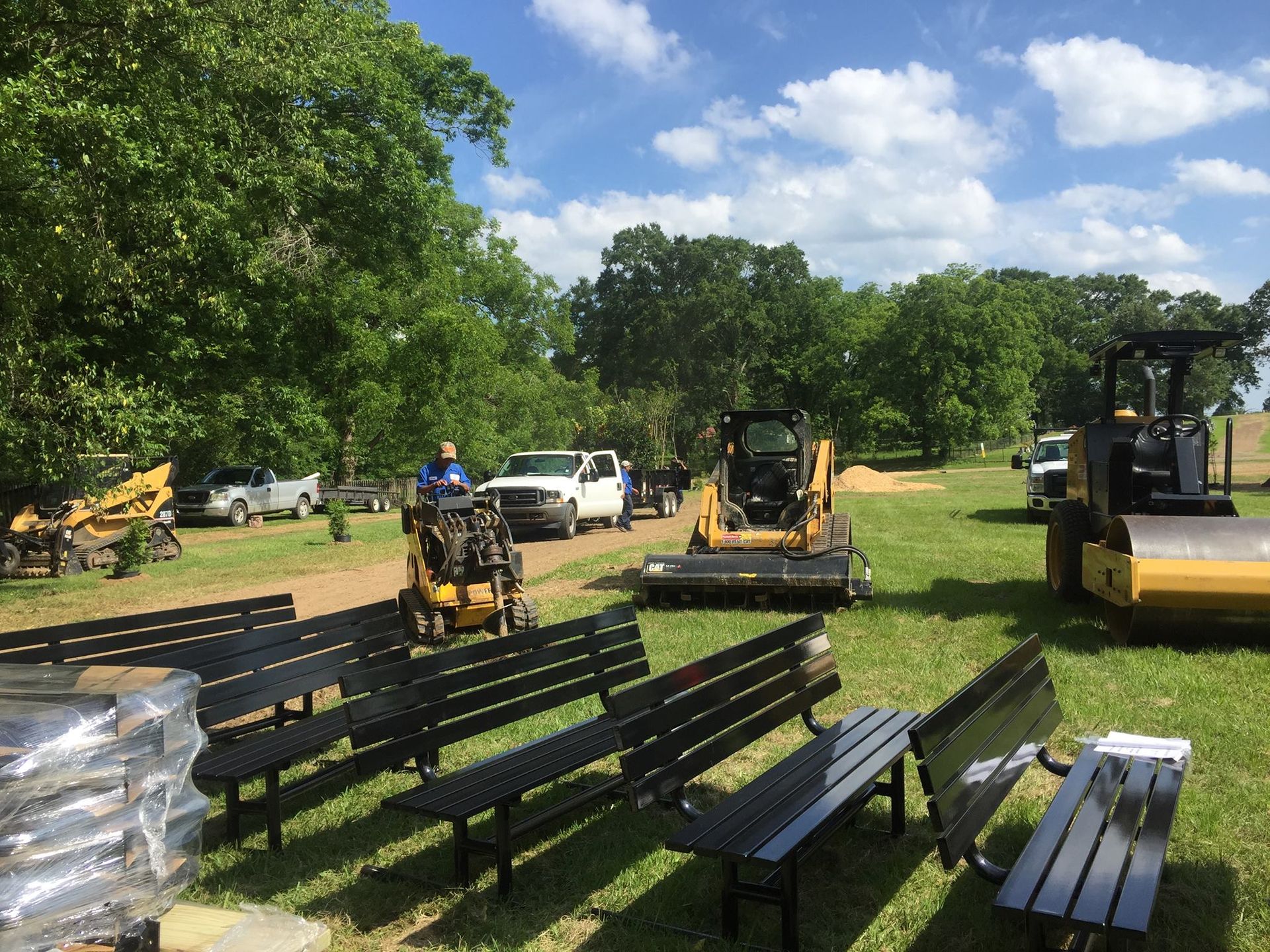 A row of benches and tractors in a grassy field