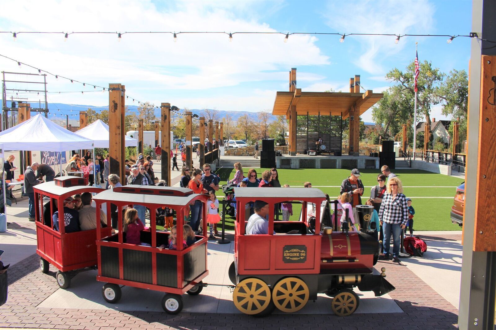 A group of people are riding a train in a park.