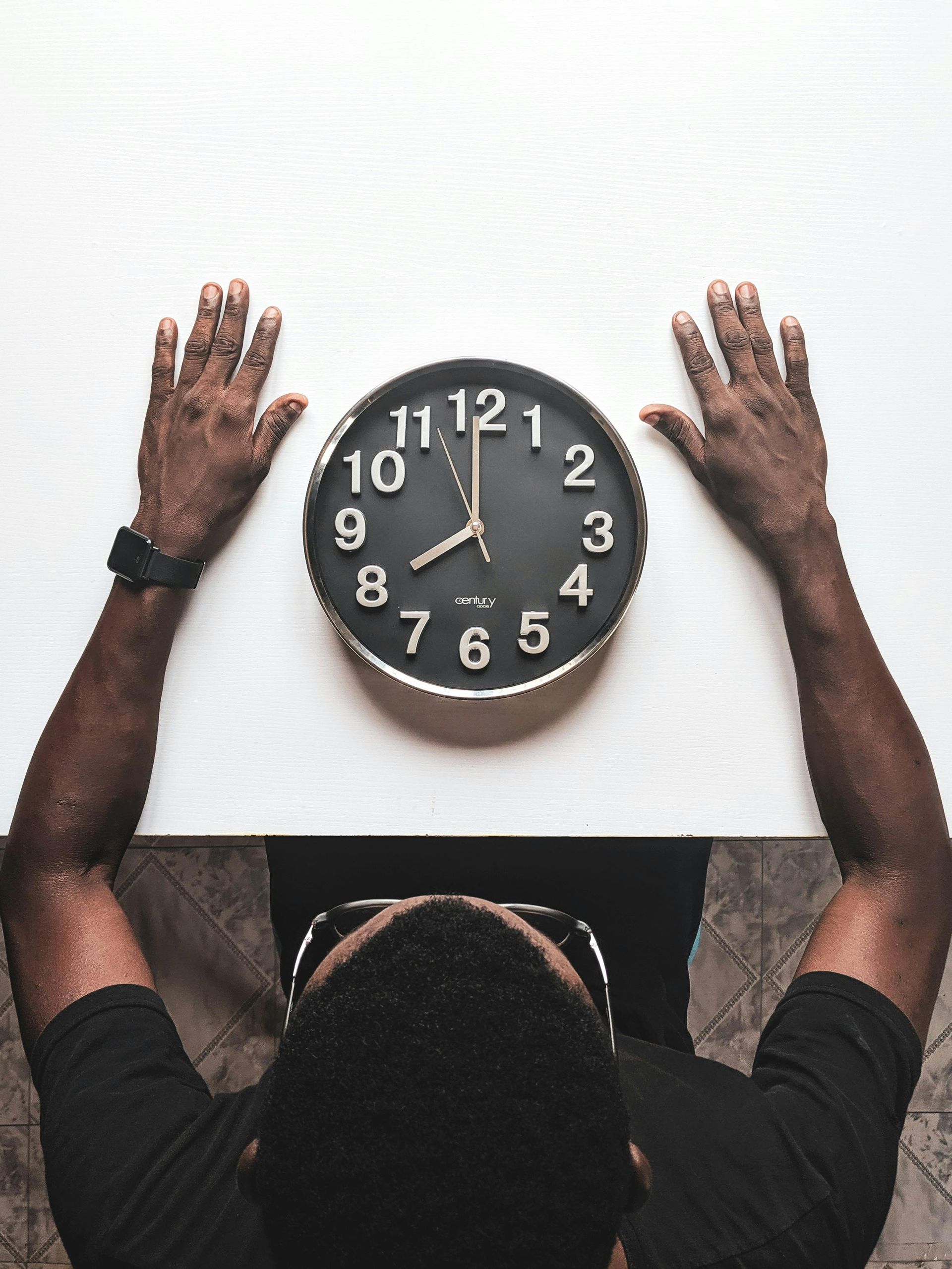 Un homme qui regarde une horloge posée sur la le
