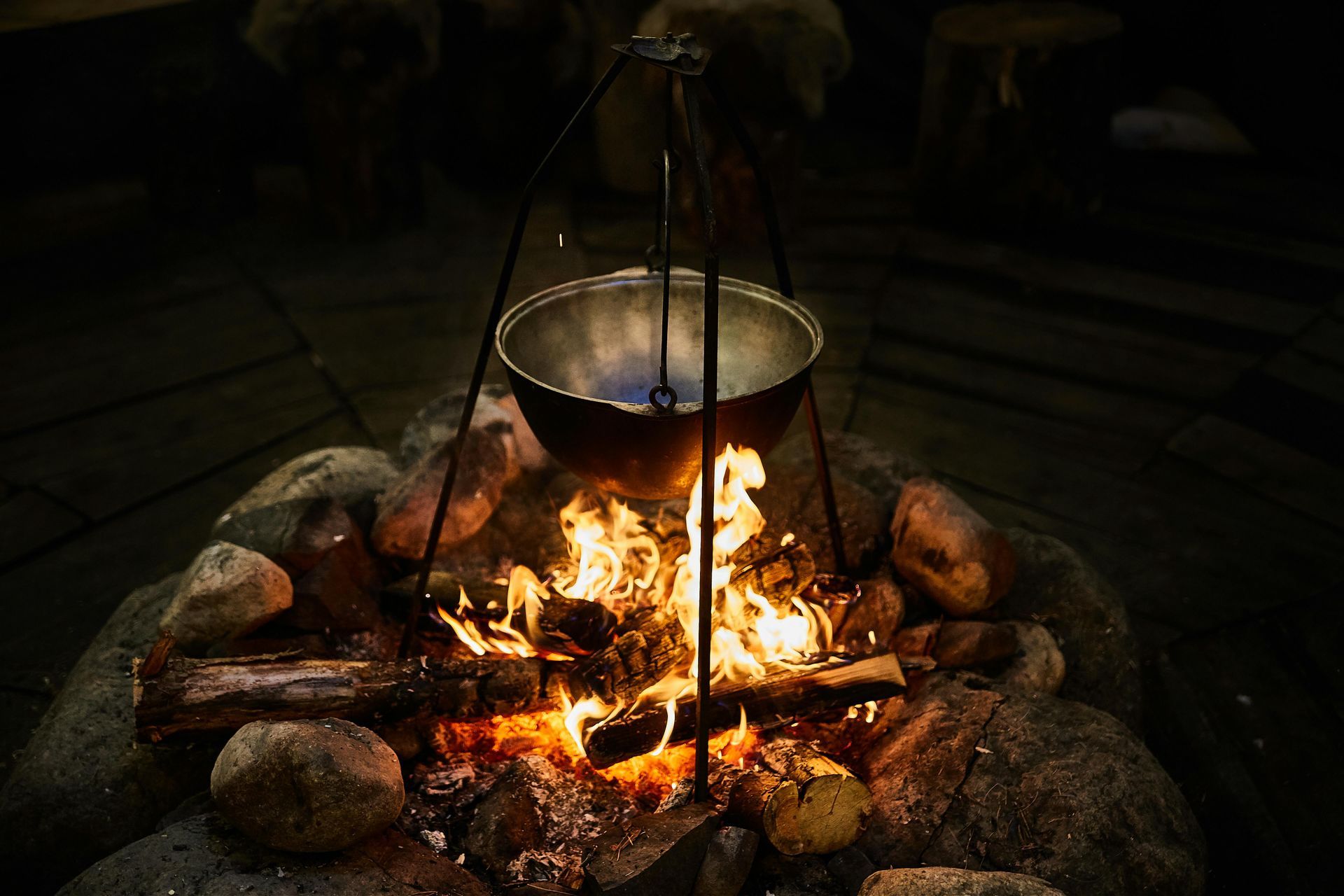 Fire pit with a metal pot hanging over flames.